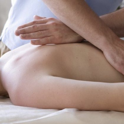 A therapist easing a patient's back pain